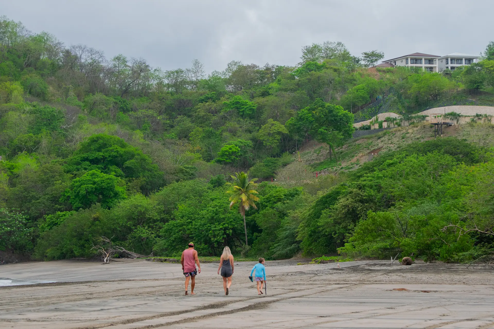Family walking together along a wide Guanacaste beach